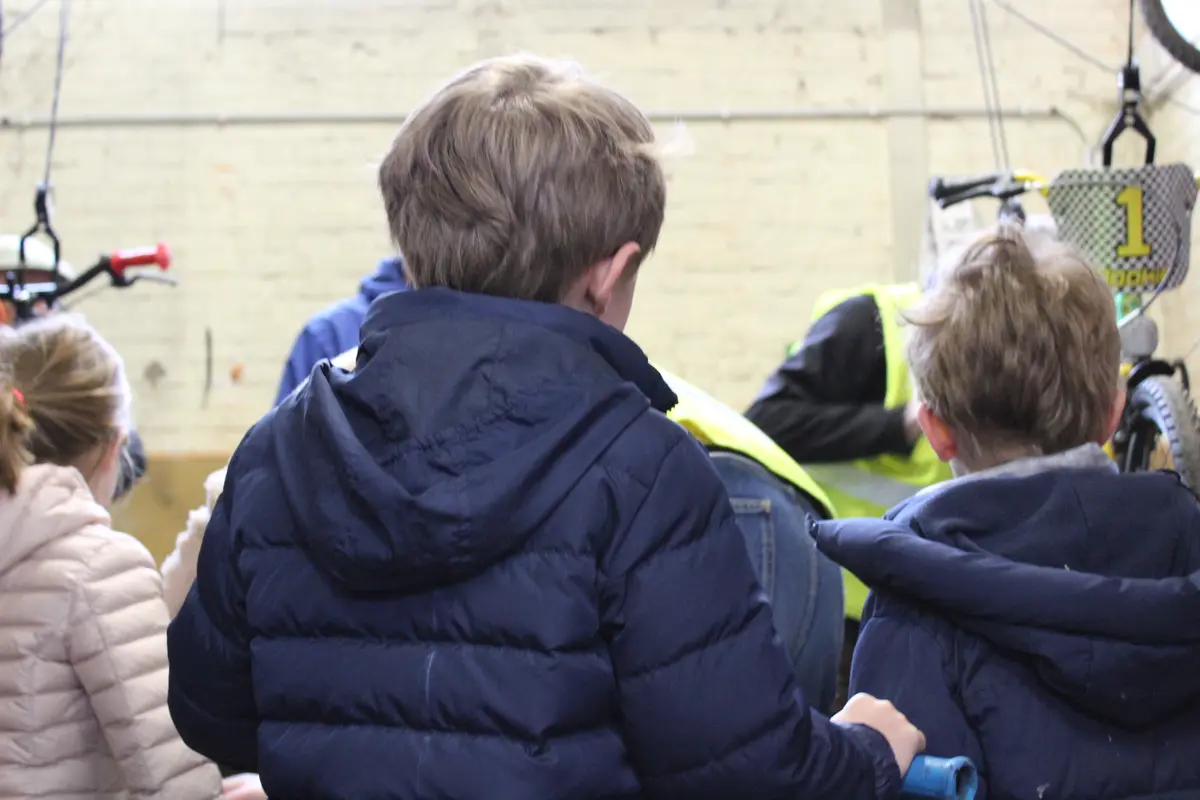 Enfants attendant la vérification finale des vélos par des bénévoles à la Fietsbieb de Tervuren